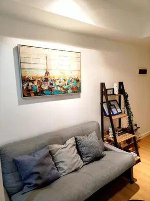 a couch in a living room with a painting on the wall at Azure De Joaquin in Manila