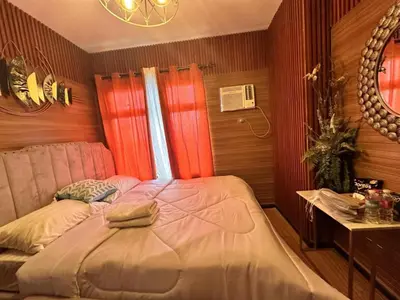 a bedroom with red curtains and a bed in it at Modern 1 BR Condo near Airport, MOA, PICC, Star City, OKADA With Fast WIFI & Netflix Free Pool Access in Sampong
