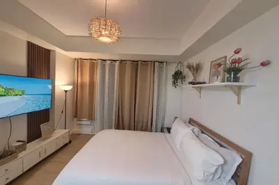 a bedroom with a bed and a flat screen tv at Azure staycation miami tower in Manila