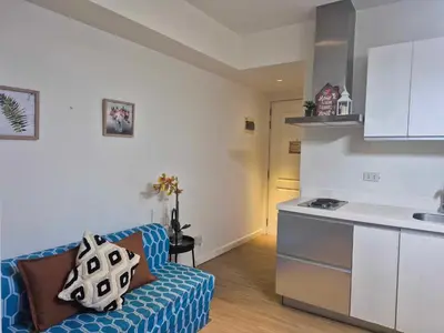 a living room with a couch and a kitchen at Azure urban residences bicutan parañaque city in Manila