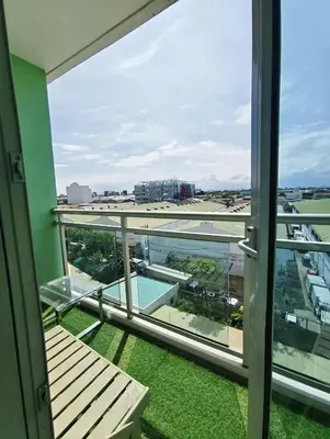 a balcony with a bench and a view of an airport at Azure Urban Resort Residences by JEs Cabin in Manila