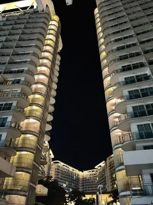 two tall buildings in a city at night at Azure Urban Resort Residences by JEs Cabin in Manila