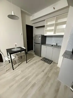 a kitchen with a table and a dining room at The Nest - Woodlands in Manila