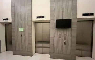 a row of elevators in a building with a television at The Nest - Woodlands in Manila