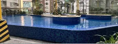 a large swimming pool with blue tiles in a building at The Nest - Woodlands in Manila