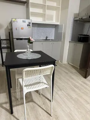 a kitchen with a black table and a white chair at The Nest - Woodlands in Manila