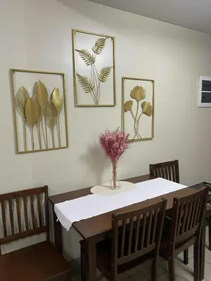 a dining room table with a vase of flowers on it at Palme d'Or Stay in Manila