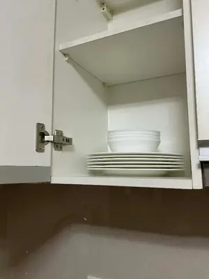 a white cabinet with plates and bowls in it at Palme d'Or Stay in Manila