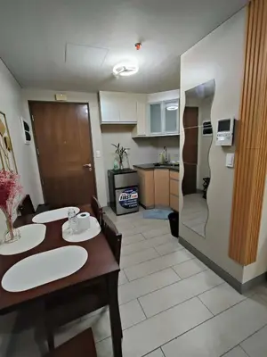 a kitchen and living room with two tables and a refrigerator at Palme d'Or Stay in Manila