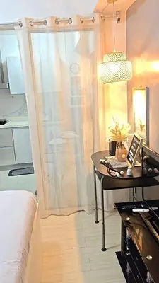 a room with a table and a bed and a window at The Infinity Staycation in Manila