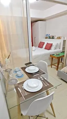 a glass table with plates on it in a room at The Infinity Staycation in Manila