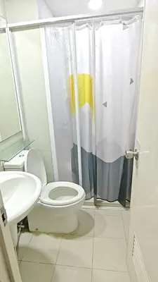a bathroom with a toilet and a sink and a shower at The Infinity Staycation in Manila