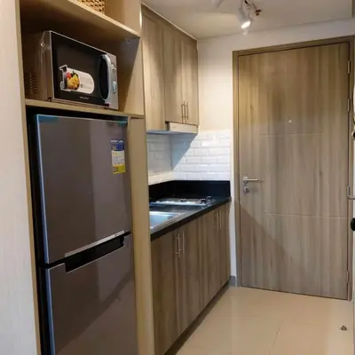 a small kitchen with a refrigerator and a microwave at 1 Bedroom in S Residences in Manila