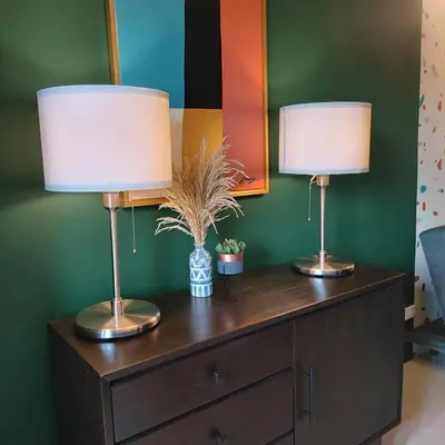 two lamps sitting on top of a wooden dresser at 1 Bedroom in S Residences in Manila