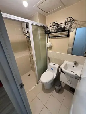 a bathroom with a shower and a toilet and a sink at Studio Near NAIA Airport in Manila