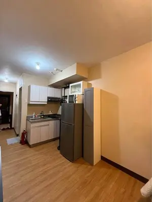 a kitchen with a refrigerator and a counter top at Studio Near NAIA Airport in Manila