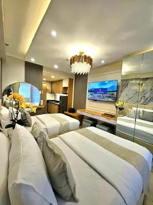 a hotel room with two beds and a flat screen tv at Mk luxury suite Moa staycation twinbed in Manila