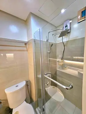 a bathroom with a toilet and a glass shower at Mk luxury suite Moa staycation twinbed in Manila