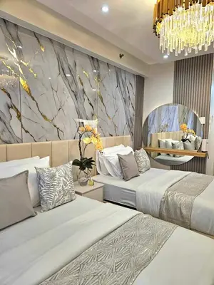 a hotel room with two beds and a wall mural at Mk luxury suite Moa staycation twinbed in Manila