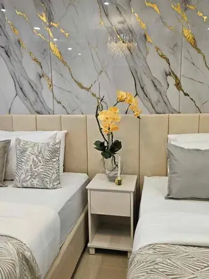 a bedroom with two beds and a vase with yellow flowers at Mk luxury suite Moa staycation twinbed in Manila