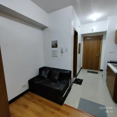 a living room with a black couch in a room at 8Adriatico Condo near US Embassy in Manila