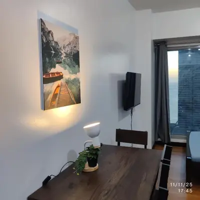 a living room with a table and a painting on the wall at 8Adriatico Condo near US Embassy in Manila