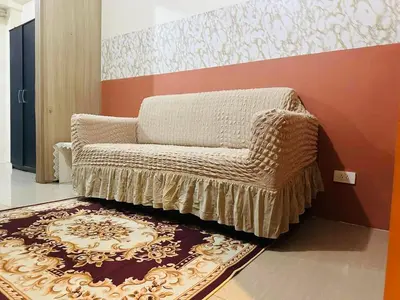 a living room with a chair and a rug at Pasay City-Shore Staycation Ph in Manila