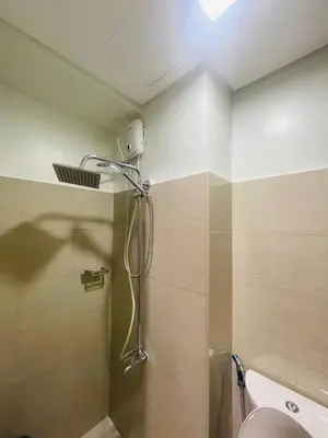a bathroom with a shower with a light on the ceiling at Pasay City-Shore Staycation Ph in Manila