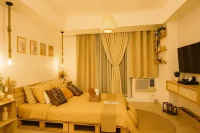 a bedroom with a bed with pillows and a television at Miami tower azure staycation in Manila