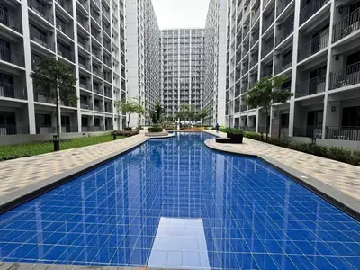 a large blue swimming pool with tall buildings at Shortstay at Shore 2 in Manila