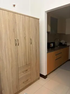 a large wooden cabinet in a kitchen with a counter at Warm & Minimalist 1BR at Two Palm, Newport, T3 in Manila