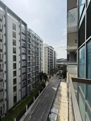 an empty street in a city with tall buildings at Warm & Minimalist 1BR at Two Palm, Newport, T3 in Manila