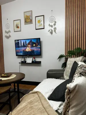 a living room with a tv on a white wall at Chic Haven Home away from home in Imus