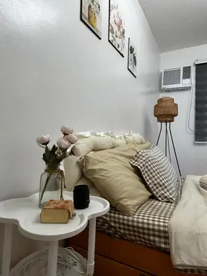 a bedroom with a bed and a table with flowers on it at Chic Haven Home away from home in Imus