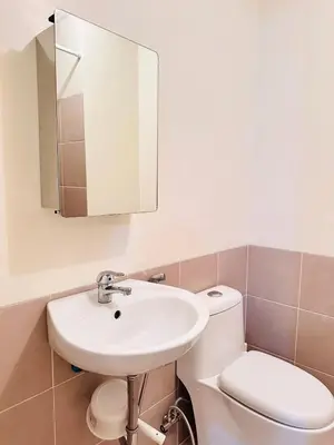 a bathroom with a sink and a toilet and a mirror at The K-Butter Lounge by Kozy Mood near BGC in Manila