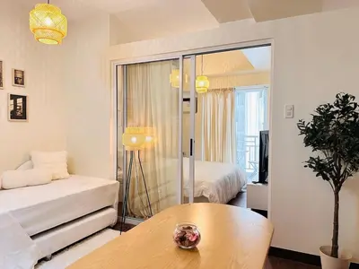 a living room with a bed and a table at The K-Butter Lounge by Kozy Mood near BGC in Manila