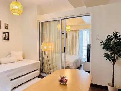 a living room with a bed and a table at The K-Butter Lounge by Kozy Mood near BGC in Manila