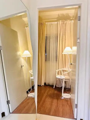 a mirror in a room with a table and two lamps at Cloud Cinema by Kozy Mood near BGC in Manila