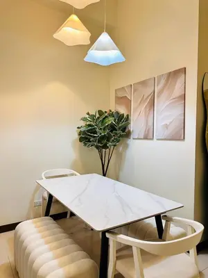 a dining room with a white table and two chairs at Cloud Cinema by Kozy Mood near BGC in Manila