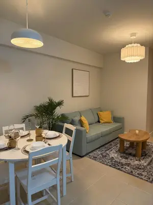 a living room with a couch and a table and chairs at Stylish Cozy Nordic 2BR Netflix & Free Parking in Manila