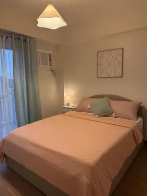 a bedroom with a large bed and a window at Stylish Cozy Nordic 2BR Netflix & Free Parking in Manila