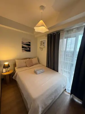a bedroom with a bed and a large window at Spacious 3BR Sucat Netflix and Free Parking in Manila