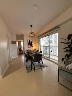 a dining room with a table and a large window at Spacious 3BR Sucat Netflix and Free Parking in Manila