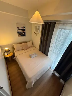 a small bedroom with a bed and a window at Spacious 3BR Sucat Netflix and Free Parking in Manila