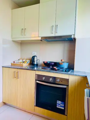 a kitchen with white cabinets and a stove top oven at High-Floor Stay near Okada, Airport, City of Dreams, Solaire and MOA with free pool and gym access in Manila