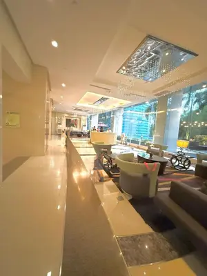 a lobby with tables and chairs in a building at Luxurious Taguig Apartment with Private Pool and Central AC in Manila