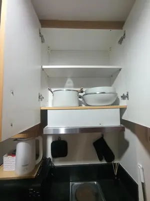 a kitchen with two pots and pans on a shelf at Classy Pool view low floor Condo near MoA in Manila