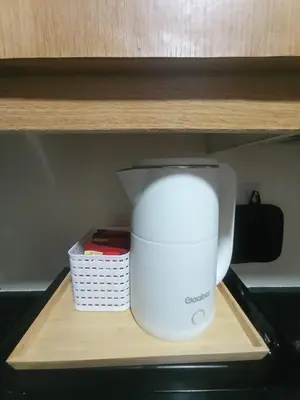 a white blender sitting on a wooden shelf at Classy Pool view low floor Condo near MoA in Manila