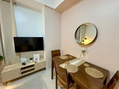 a dining room with a table and a mirror at Stylish 1BR Condo in 101 Newport City Near NAIA in Manila