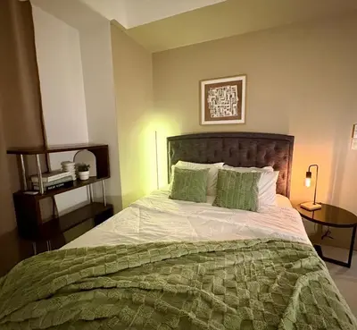 a bedroom with a bed with a green comforter at Stylish 1BR Condo in 101 Newport City Near NAIA in Manila